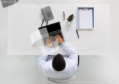 Image of doctor typing on laptop at clinic