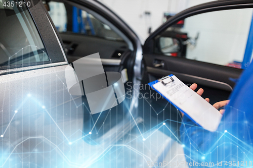 Image of auto mechanic man with clipboard at car workshop