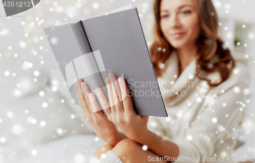 Image of close up of young woman reading book at home