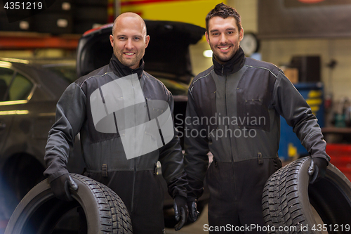 Image of auto mechanics changing car tires at workshop