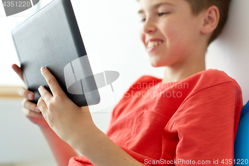 Image of close up of boy with tablet pc computer at home