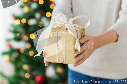 Image of close up of man with christmas gift at home