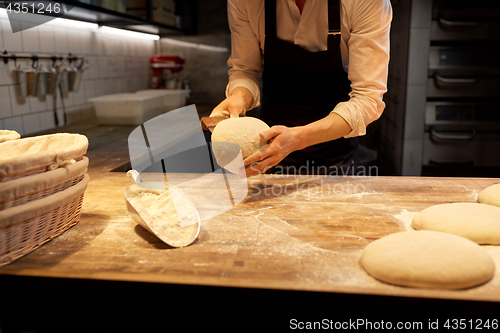 Image of baker portioning dough with bench cutter at bakery