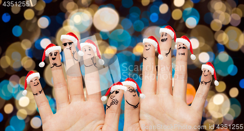 Image of hands and fingers in santa hats at christmas