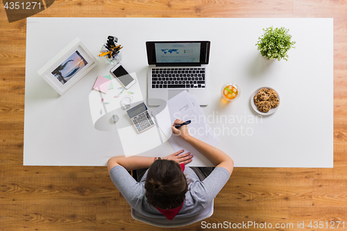 Image of hands with calculator and papers at office table