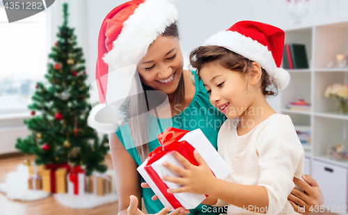 Image of happy mother and daughter with christmas gift