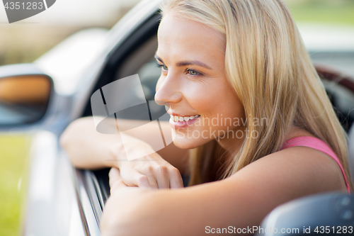 Image of close up of happy young woman in convertible car