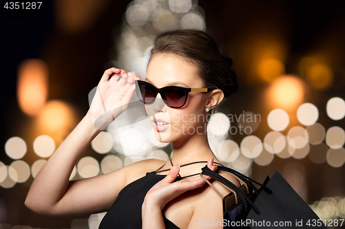 Image of woman in shades with shopping bags at christmas