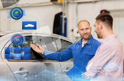 Image of auto mechanic with clipboard and man at car shop