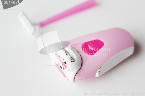 Image of epilator and safety razor on white background