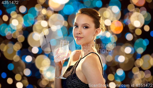 Image of young asian woman drinking champagne at party