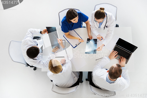 Image of group of doctors with x-rays and laptop at clinic