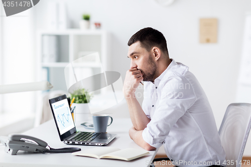 Image of businessman with charts on laptop screen at office