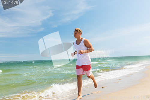 Image of happy man running along summer beach