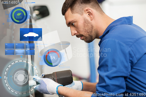 Image of mechanic with screwdriver changing car tire