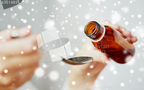 Image of woman pouring medication from bottle to spoon