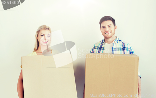 Image of smiling couple with big boxes moving to new home