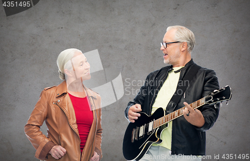 Image of happy senior couple with electric guitar