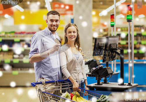 Image of couple buying food at grocery self-checkout