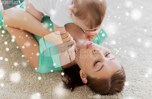 Image of happy mother playing with little baby at home