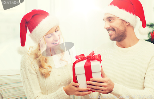 Image of happy couple at home with christmas gift box