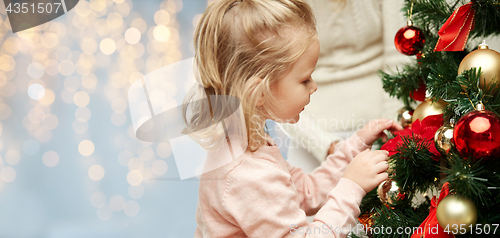 Image of close up of little girl decorating christmas tree