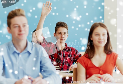 Image of student boy raising hand at school lesson