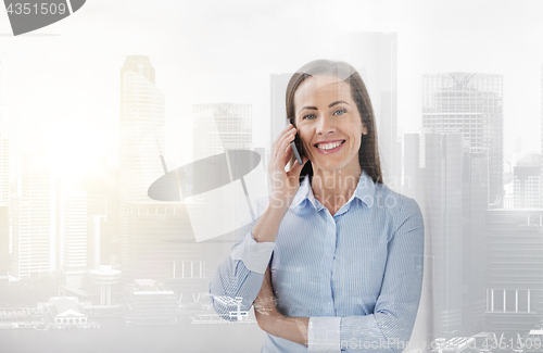 Image of businesswoman calling on smartphone at office