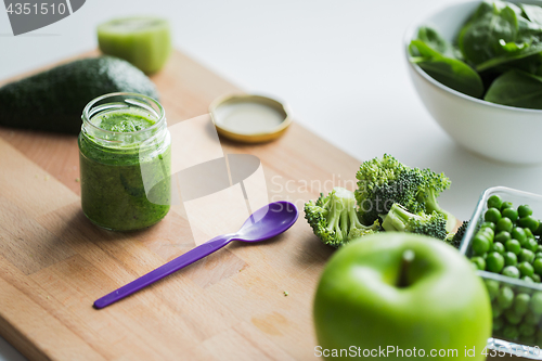 Image of jar with puree or baby food on wooden board