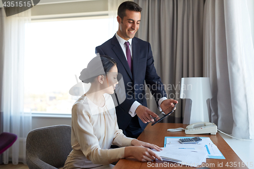 Image of business team with papers working at hotel room