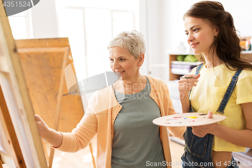 Image of women with easels and palettes at art school