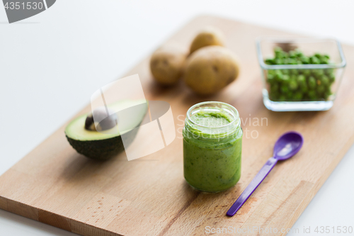 Image of jar with puree or baby food on wooden board