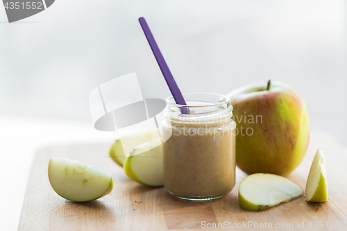 Image of jar with apple fruit puree or baby food on table