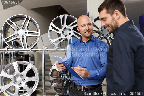 Image of customer and salesman at car service or auto store