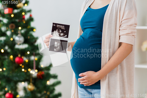 Image of pregnant woman with ultrasound images at christmas