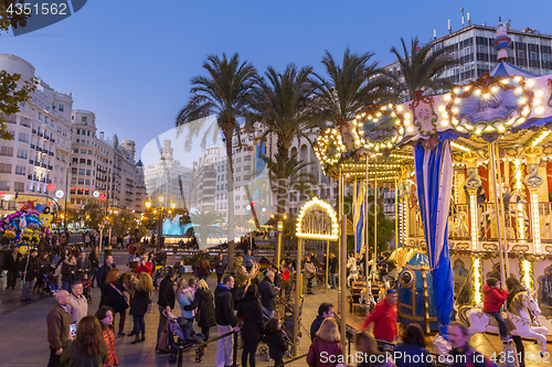 Image of Christmas fair with carousel on Modernisme Plaza of the City Hall of Valencia, Spain.