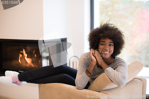 Image of black woman in front of fireplace