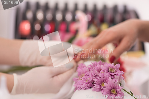 Image of Woman hands receiving a manicure