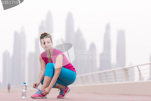 Image of woman tying shoelaces on sneakers