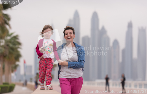 Image of mother and cute little girl on the promenade