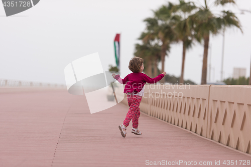 Image of cute little girl on the promenade by the sea