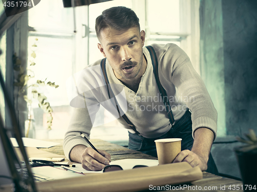 Image of Architect working on drawing table in office