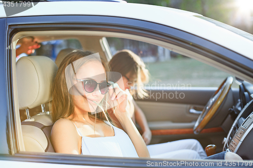 Image of The young women in the car smiling