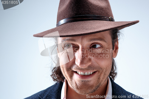 Image of Young man portrait with hat on gray studio background.