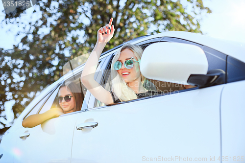 Image of The young women in the car smiling