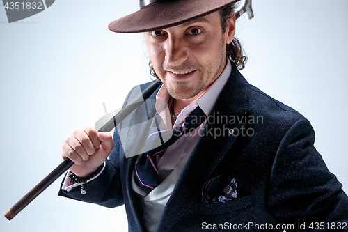 Image of Young man portrait with hat on gray studio background.