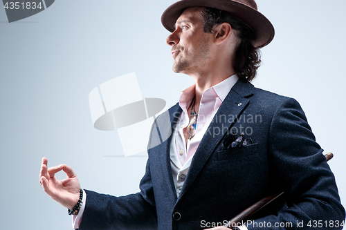 Image of Young man portrait with hat on gray studio background.