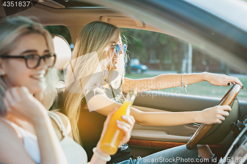 Image of The young women in the car smiling