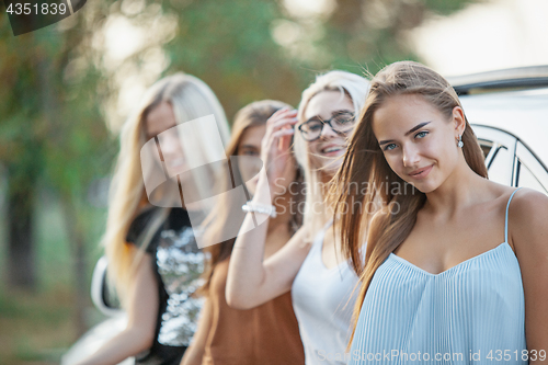 Image of The young women standing near the car