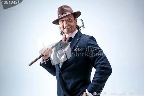 Image of Young man portrait with hat on gray studio background.